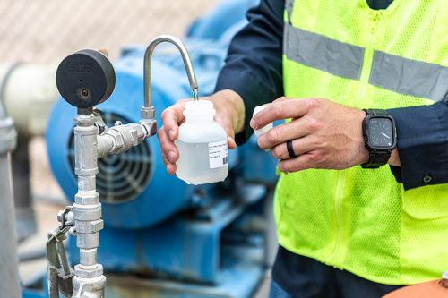District staff collecting a water sample at the water facility.